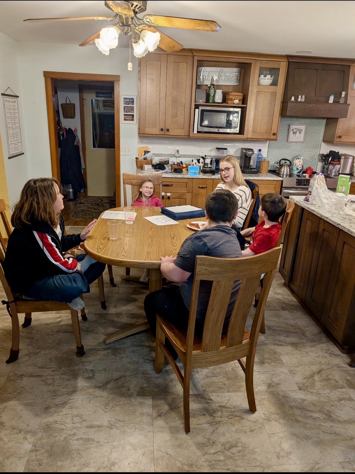 A group of youth sitting around a table in a dining room.