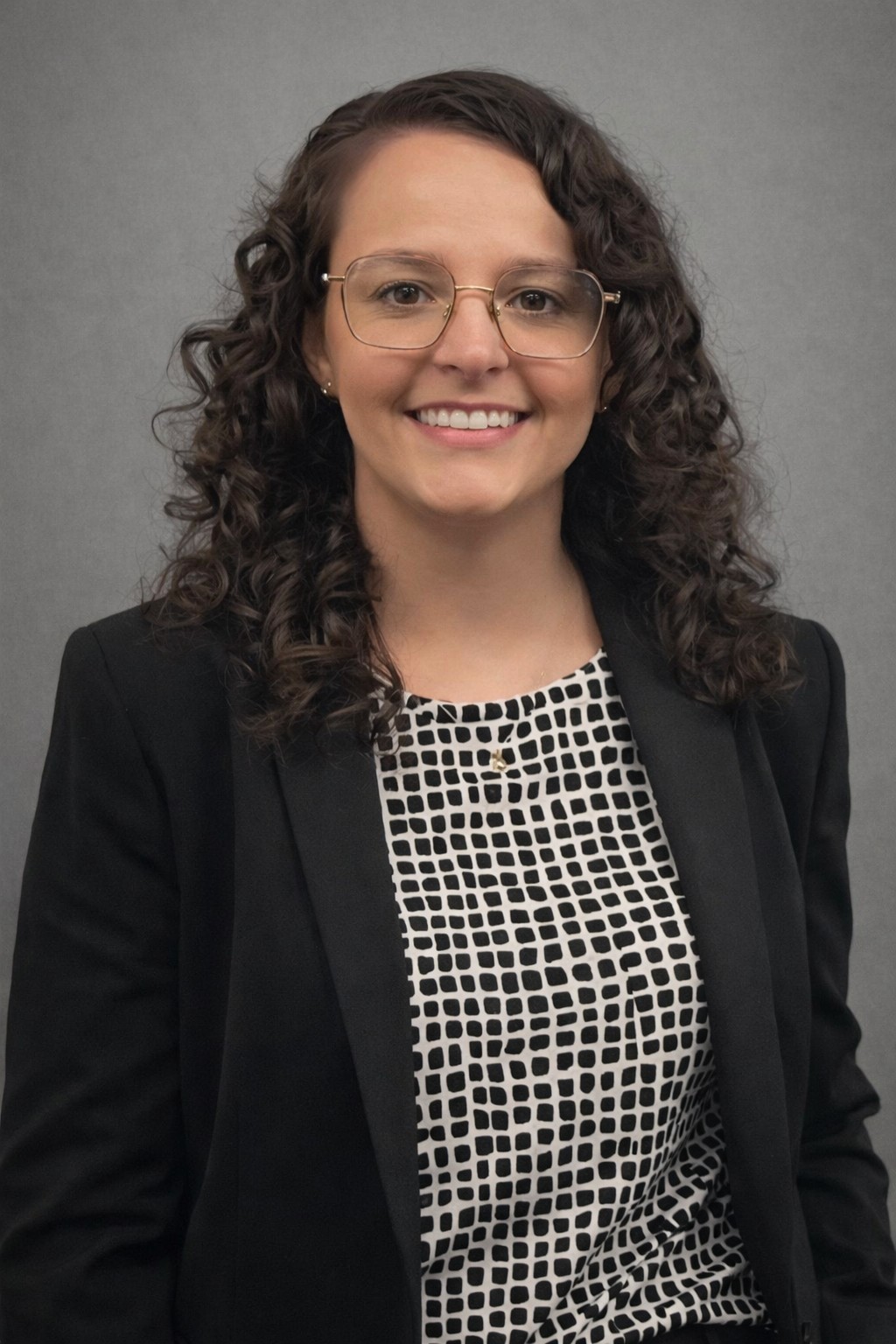 Studio portrait of Barbara Biduski facing the camera against a neutral gray background.