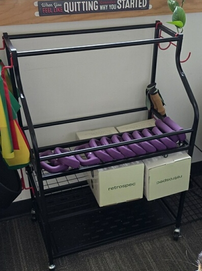 Small metal equipment cart holding hand weights.