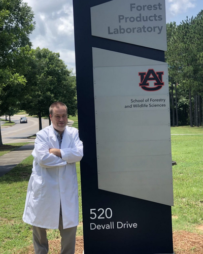 Image of Dr. Brian Via next to an Auburn University Forest Products Development Center sign.