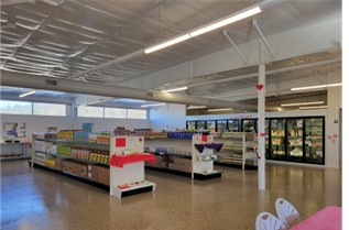 Interior view of a grocery store with shelves and refrigerated units.
