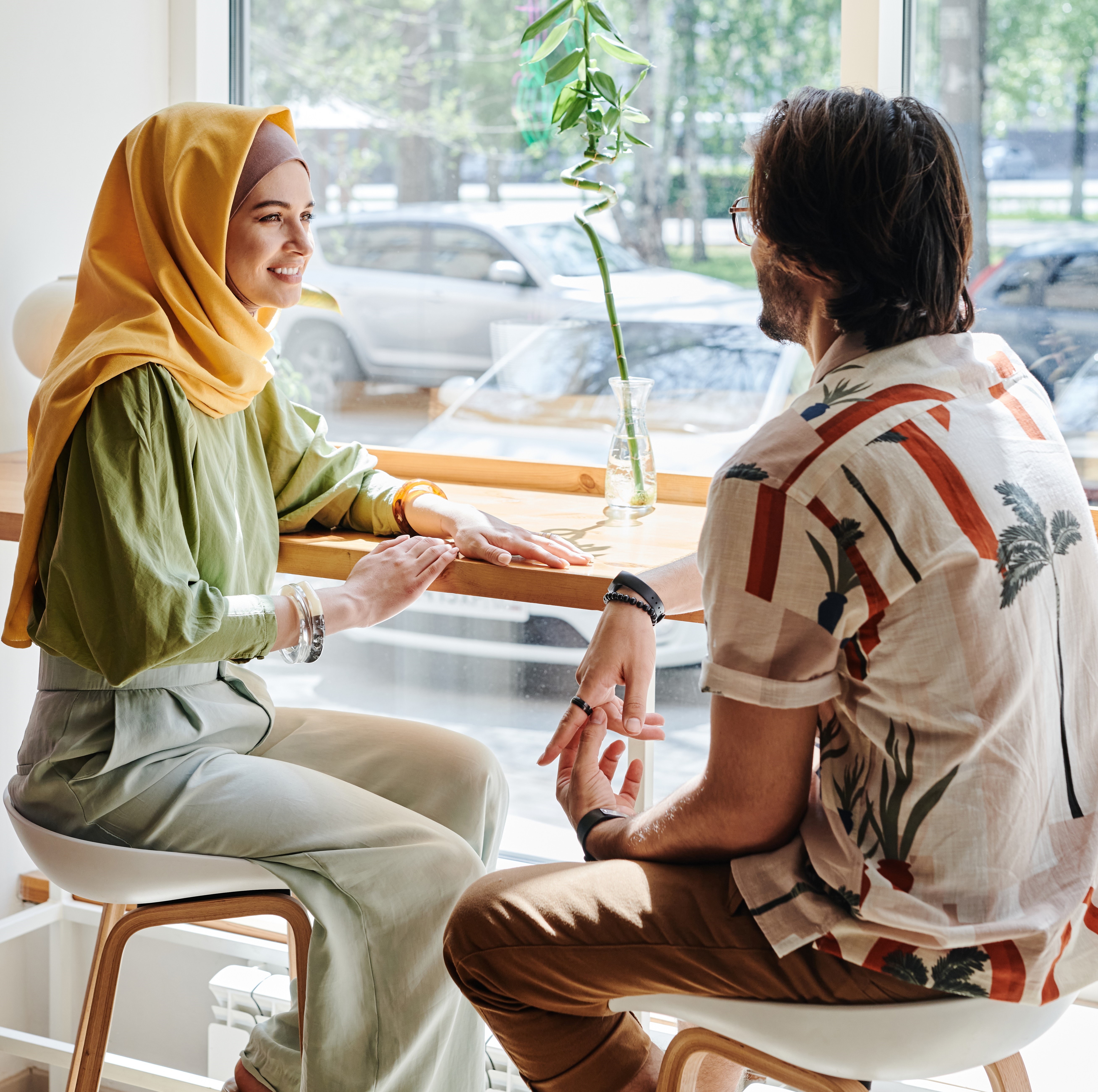 Young man and woman talking while sitting at a counter.