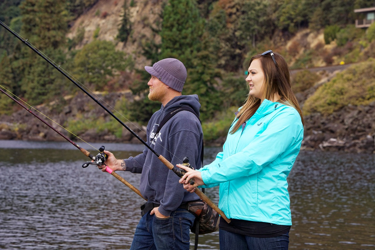 Woman and man fishing from water's edge